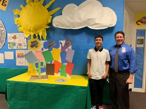 a student shows off a full wall length project