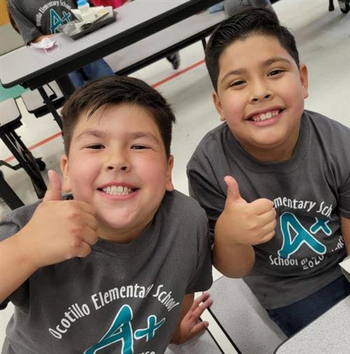 two students wear A+ shirts