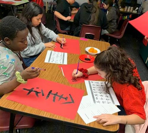 students paint chinese characters