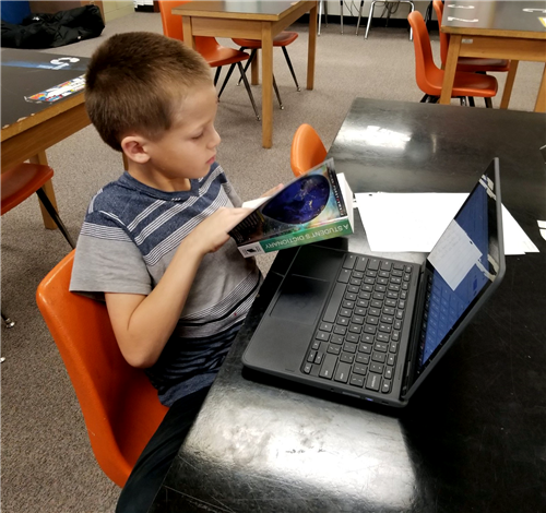 a student works on a chromebook