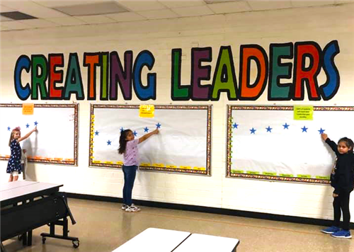 students point to thier name on the leader board