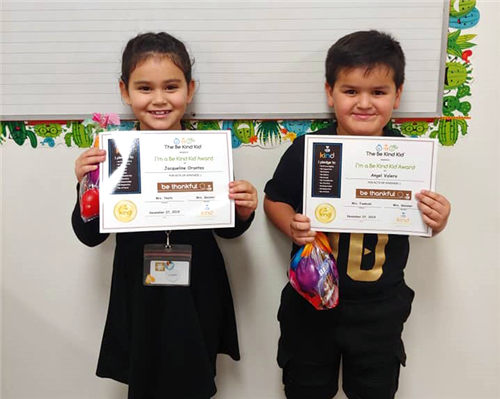 two students recieve certificates